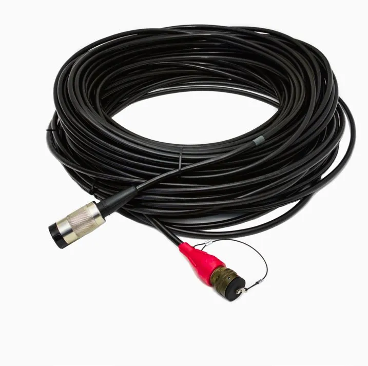 A heavy black cable coiled in a loop, with a round steel-and-black connector at one end and a red-sleeved military-style connector with a dust cap at the other
